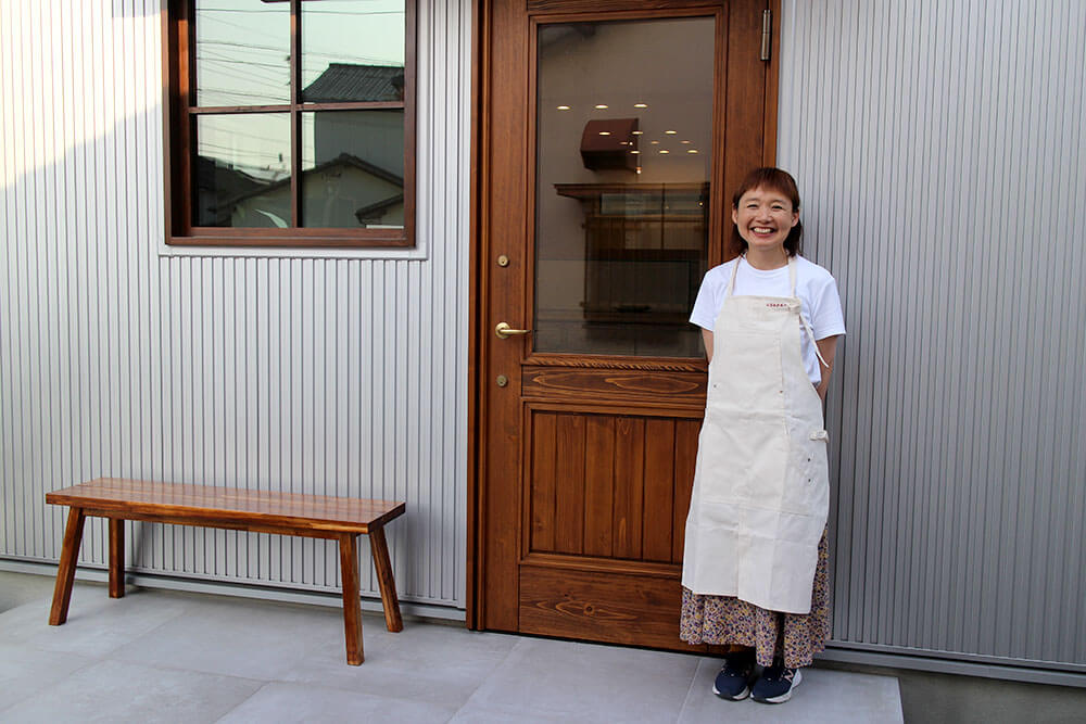 手づくりパンとお菓子のお店usapanの木製玄関ドアと笑顔のオーナー様